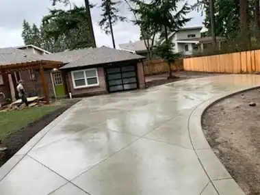 Curved Driveway along Cedar Fence: concrete driveway work by Redmond Concrete, concrete contractor serving Kirkland (photo 1 of 2)